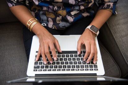 woman's hands typing on a laptop