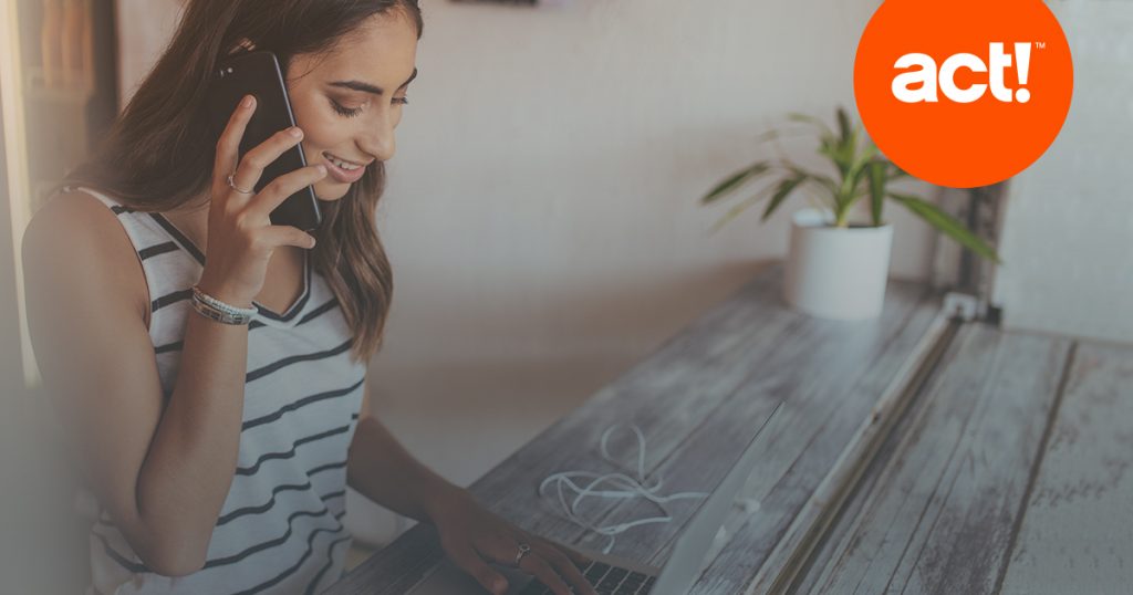 a stock photo of a woman talking on a cellphone while keying on a laptop. 