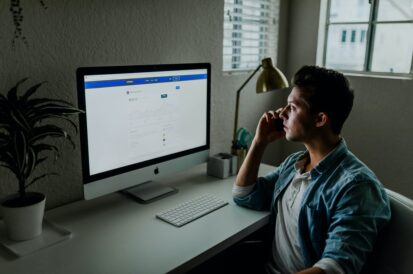 person sitting at desk and looking at a computer monitor